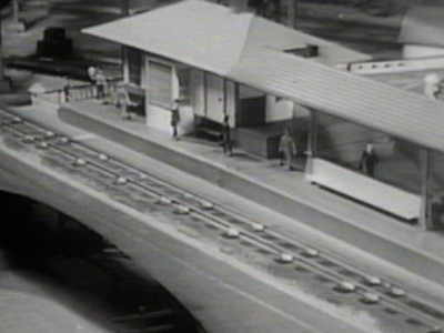 Elevated Station from Above This view of the elevated station at the right end of the layout marks the beginning of the wall around the industrial area on which the main circles and returns to the mountains at the center and left portions of the layout. The station was a 755 talking station as demonstrated in the Boys' Railroad Club TV program. This station was later replaced with the big city style station, presumably a 799 talking station.