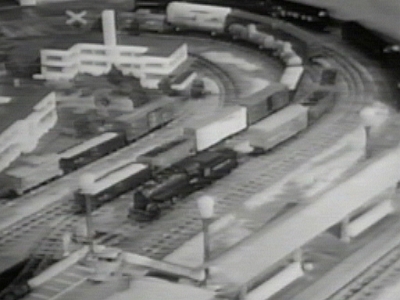 Industrial Area with 2 factories This view of the industrial area appears in the 5th episode of the Boys' Railroad Club. In this photo, both factories that appear in the Buckage Photos and other photos are present. Apparently the "A.C. Gilbert Co." sign has not yet been placed on the more distant factory.