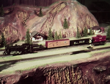 HO 0-6-0 Set This photo may have been taken on the 200 5th Avenue layout. We can probably date this photo to 1959 or possibly 1960 as it shows one of the 0-6-0 HO sets offered in those years. I suspect these photos are from 1959, rather than 1960 as the collection of photos omits the C&O Alco DL-600 set offered in 1960, but not in 1959.. The only photo I have seen that shows that entire 200 5th Avenue layout appears to have an elevated area for HO and that is where I think this photo might have been taken. I have not been able to identify any Gilbert advertising which uses this photo.
