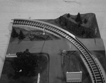 This panel has a more flattened hill on the outside of the curve and the road junction crossing the tracks, but still not hill development on the inside of the curve.