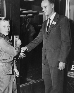 A.C. Gilbert Jr. & Boy Scout open the door.