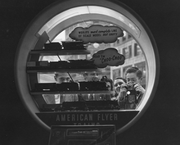 Curious onlookers as seen from inside the Hall of Science through the trains window