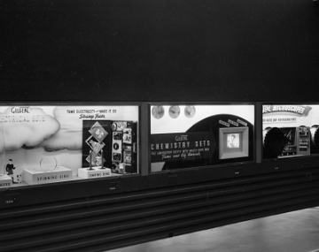 Close up of the second bank of windows on the right at the far back of the first floor view. (2 slides back) They are on the other side of the central lobby across from the 25th St. entrance. You can see the "Push Me" buttons used to operate animations in the windows.