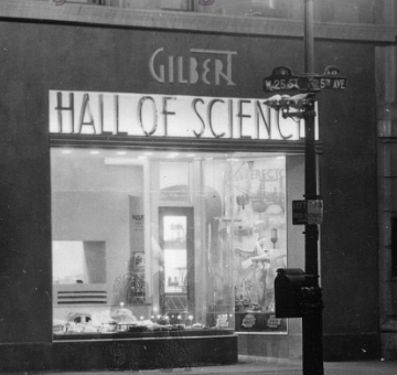 An enlarged section of the previous photo showing the American Flyer display window. Can you see the ghosts of two passersby who stopped long enough to be caught in this long time exposure? Look for their feet in front of the window. Photo by F. M. Demarest
